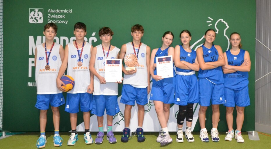Dwie szkolne drużyny z koszykówki stoją na tle baneru Akademickiego Związku Sportowego