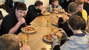 Chłopcy z klasy 6a jedzą przygotowaną przez siebie pizzę