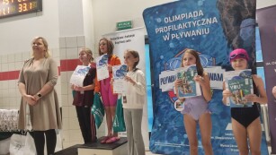 Dziewczynki stoją na podium po wręczeniu medali przez p. Otylię Jędrzejczak i p. Mariusza Siembidę