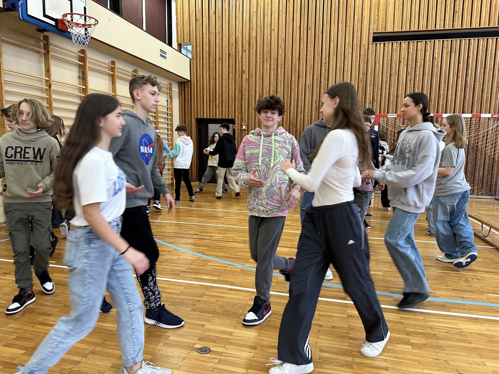 Uczniowie podczas tańca w sali gimnastycznej.