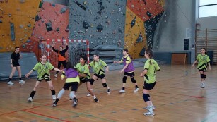 dziewczęta występujące w zawodach grają w piłkę ręczną w hali sportowej