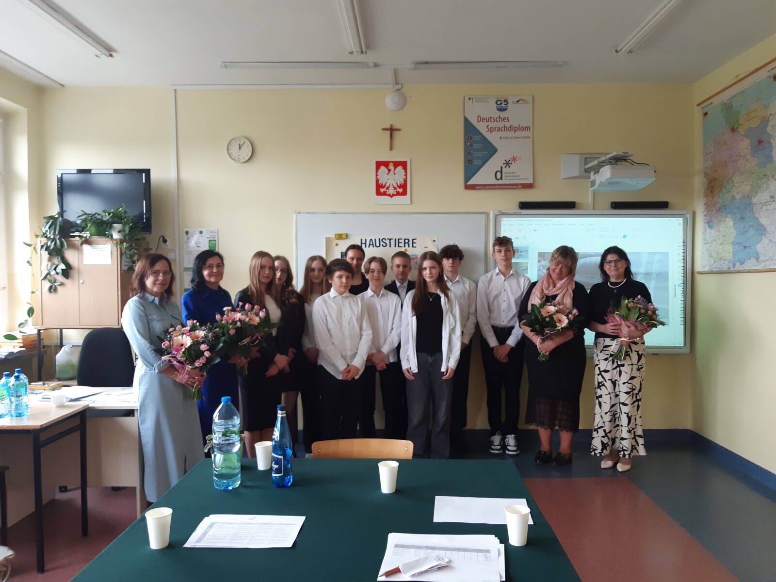 Grupowe zdjęcie uczniów wraz z egzaminatorami i panią dyrektor po ogłoszeniu wyników z egzaminu ustnego DSD1.