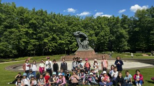 Uczniowie klas 2b i 2c podczas wycieczki do Warszawy stoją przed fontanną w Łazienkach Królewskich.