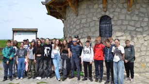 Uczestnicy wyjazdu z przewodnikiem stoją przed wieżą widokową w Krasnobrodzie.
